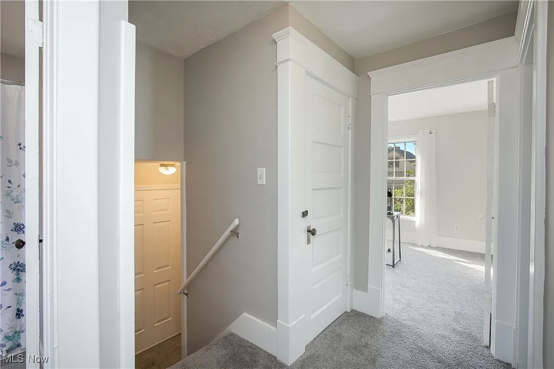 Corridor featuring an upstairs landing and carpet floors