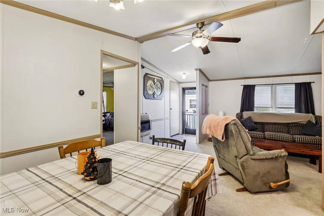 Bedroom featuring crown molding, carpet floors, lofted ceiling, and a ceiling fan