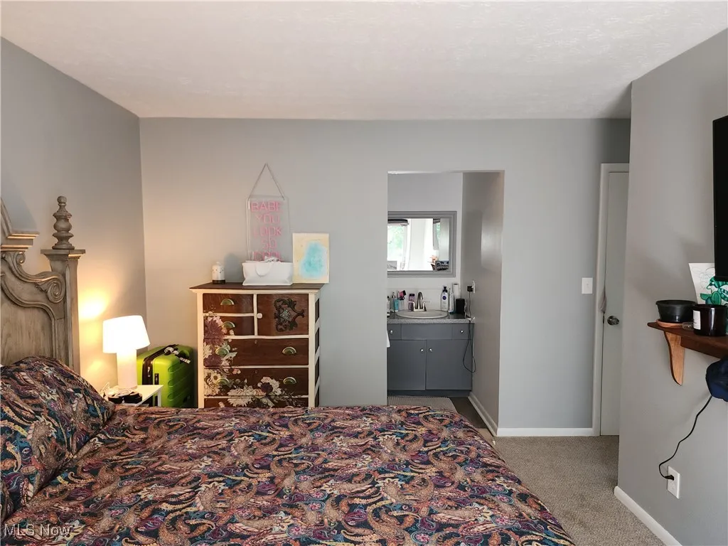 Bedroom #1 featuring light carpet and connected bathroom
