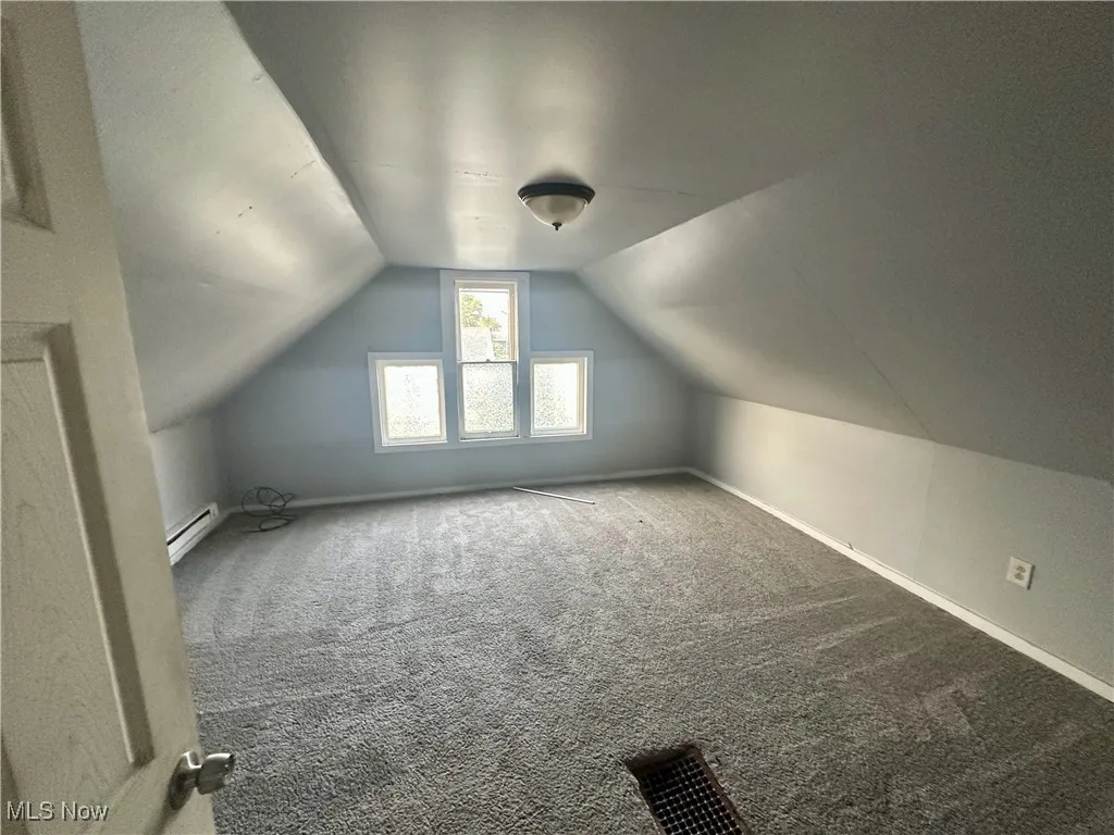 Bonus room with vaulted ceiling, carpet flooring, and baseboard heating