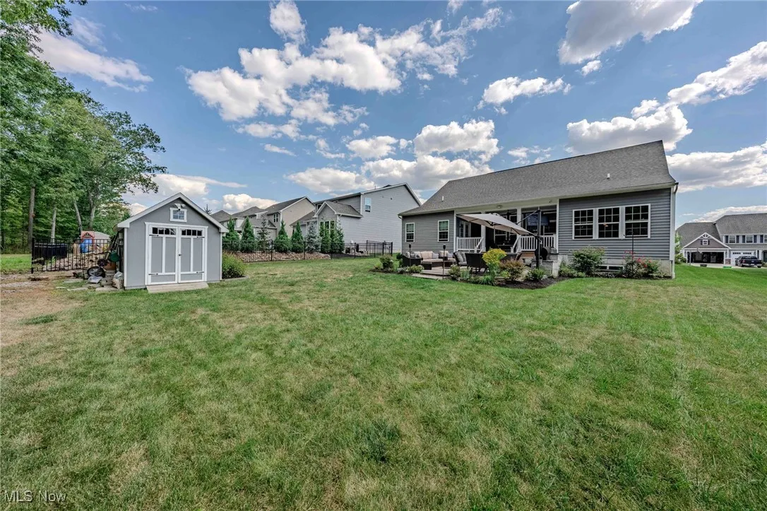 View of yard featuring a shed, a patio, and a residential view