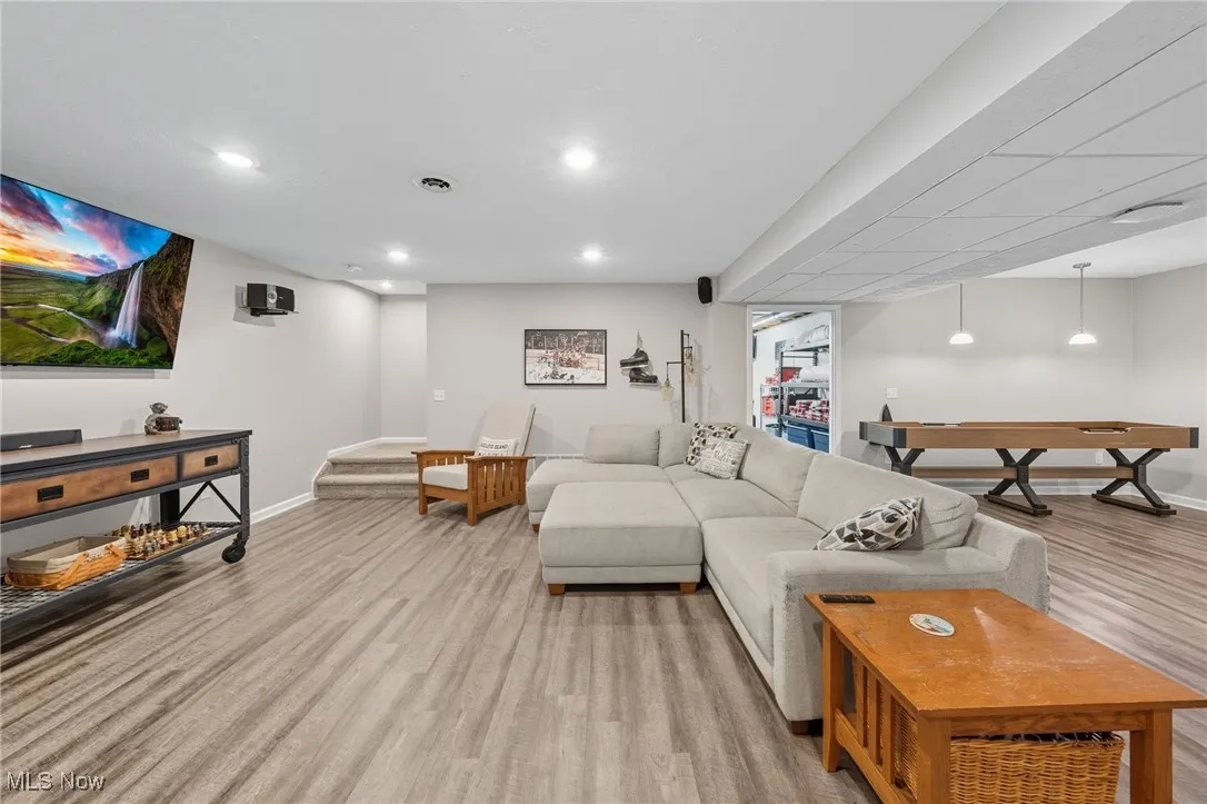 Living area with light wood-style flooring, stairs, and recessed lighting