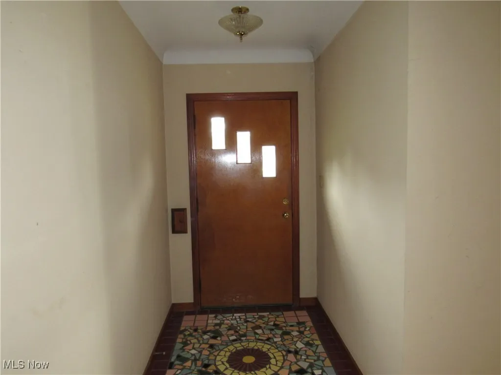 Doorway to outside with tile patterned flooring and baseboards