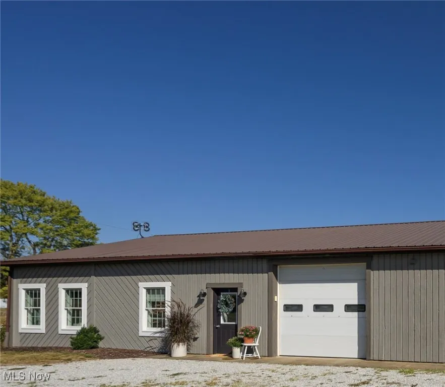 View of front of house with a metal roof and a garage