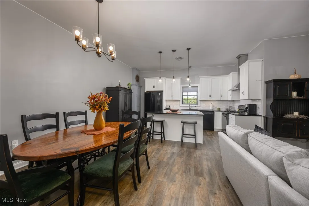 Dining space with dark wood-style floors and a chandelier