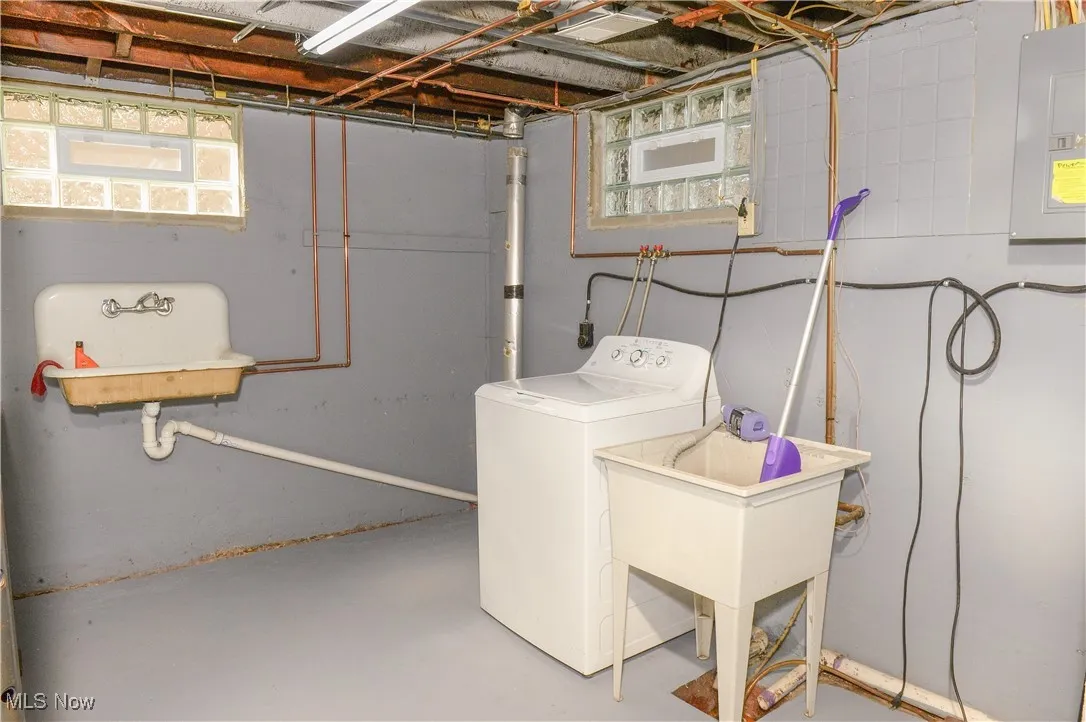 Washroom featuring washer / clothes dryer, electric panel, and plenty of natural light