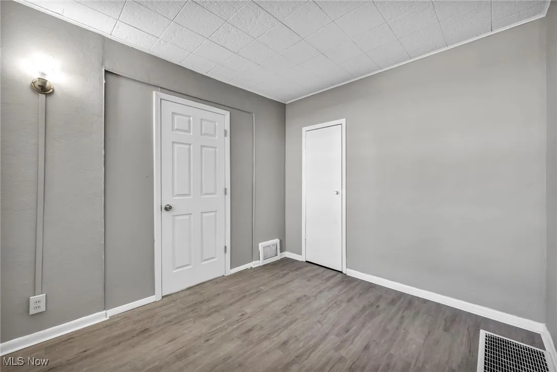 Unfurnished bedroom with wood finished floors and baseboards