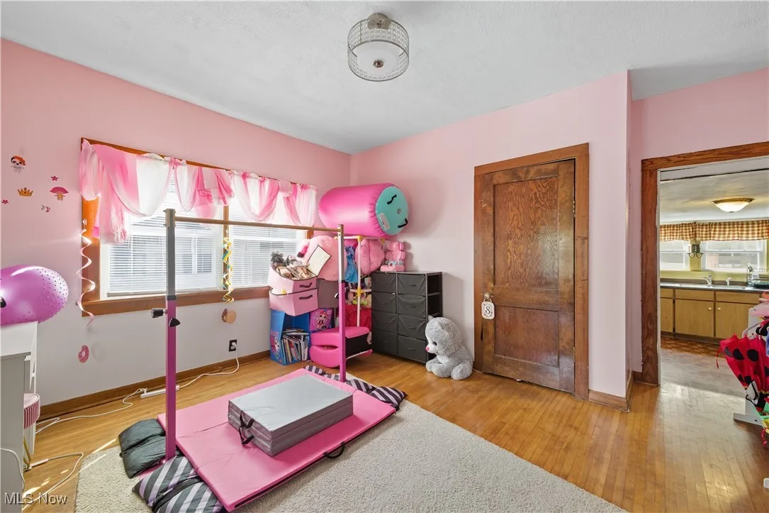 Recreation room featuring wood finished floors and baseboards