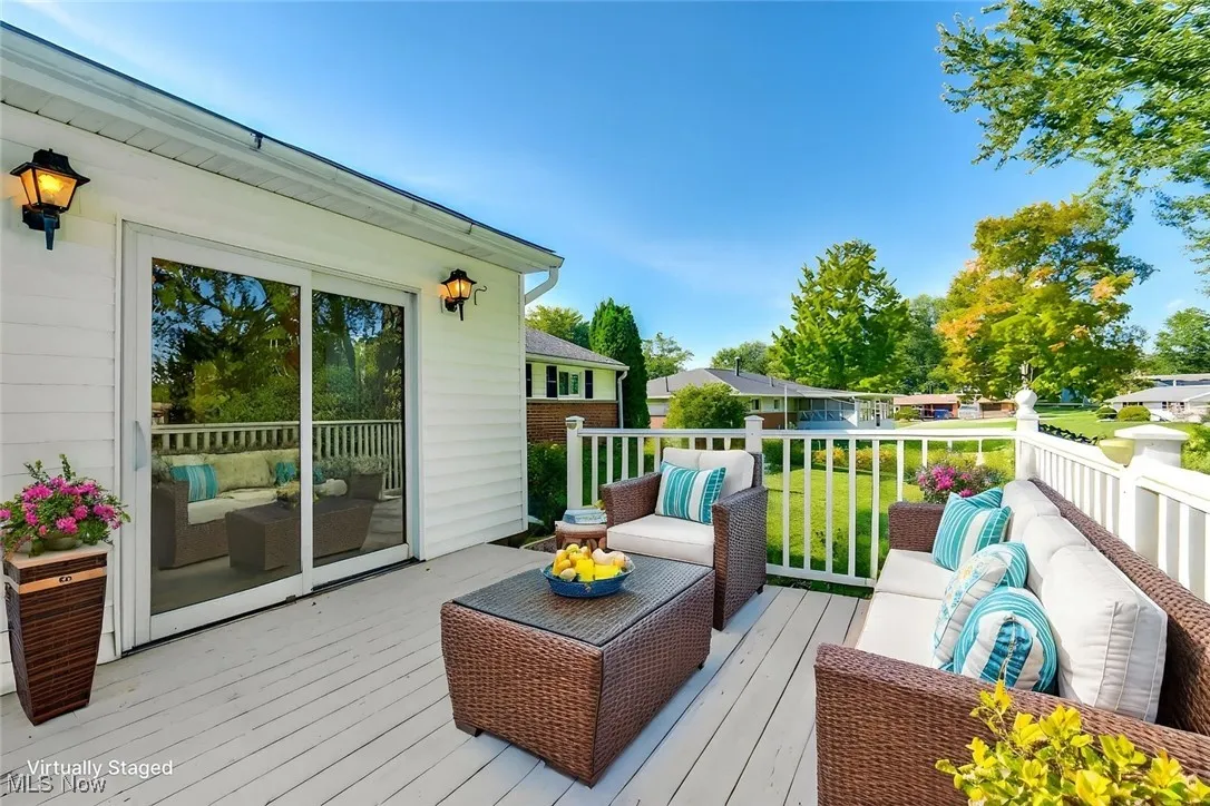 Wooden terrace with an outdoor hangout area and a lawn