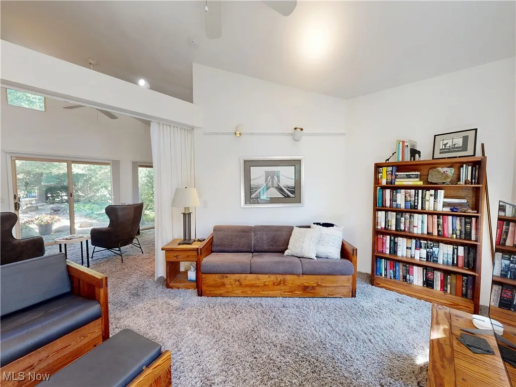 Carpeted living room with a ceiling fan