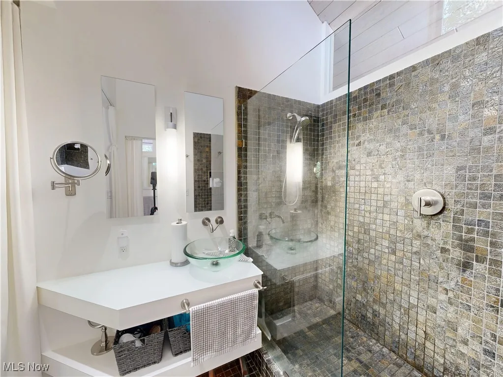 Bathroom featuring a walk in shower and vanity
