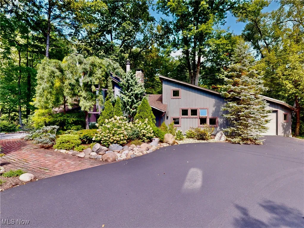 Mid-century home featuring a garage and view of wooded area