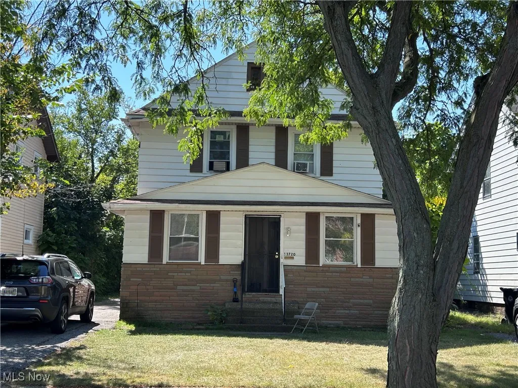 Traditional style home featuring a front lawn, entry steps, and brick siding