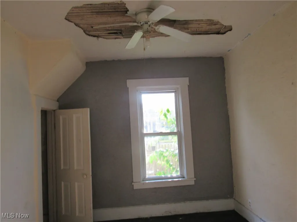 Bonus room with ceiling fan and baseboards