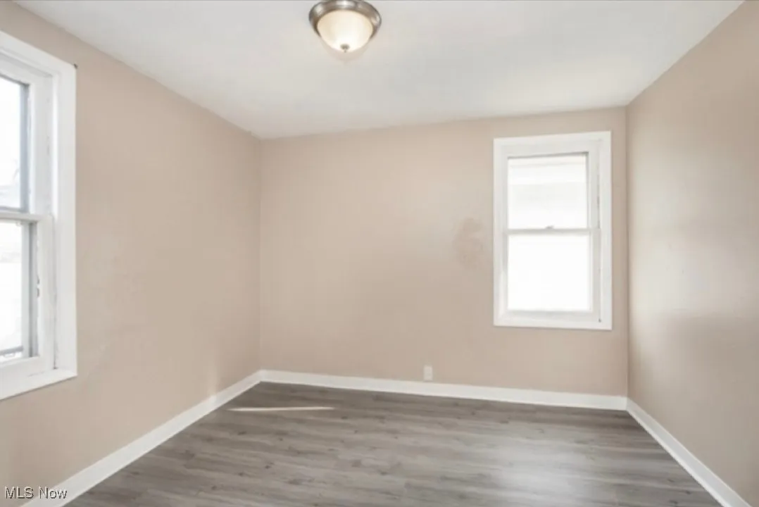 Empty room featuring baseboards and wood finished floors