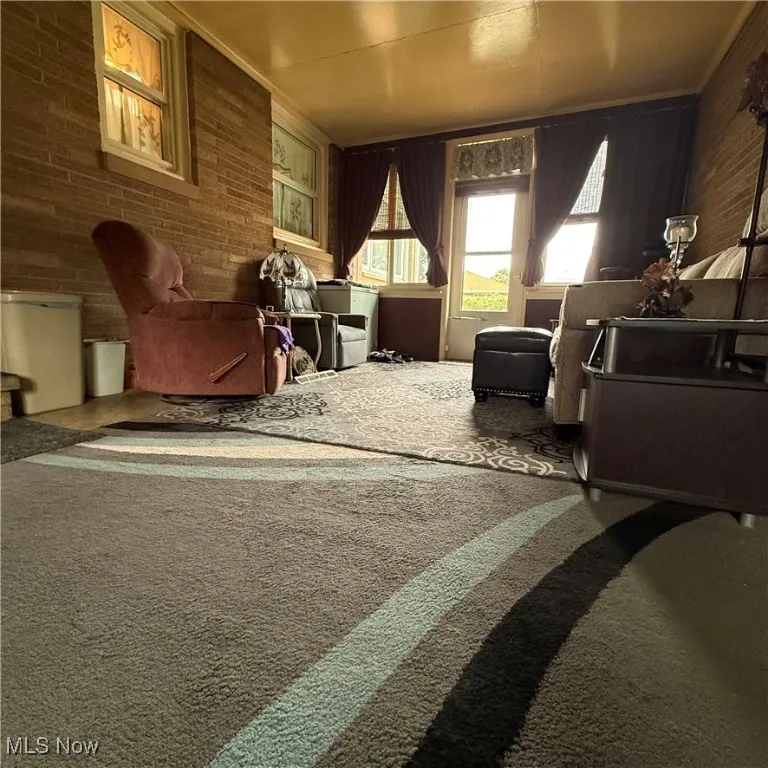 Living area with brick wall and carpet flooring