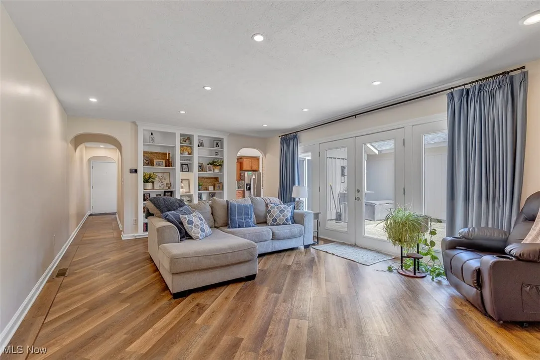 Living area featuring recessed lighting, french doors, light wood finished floors, built in features, and a textured ceiling