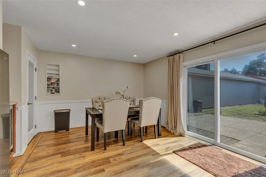 Dining space with light wood-type flooring, recessed lighting, and wainscoting