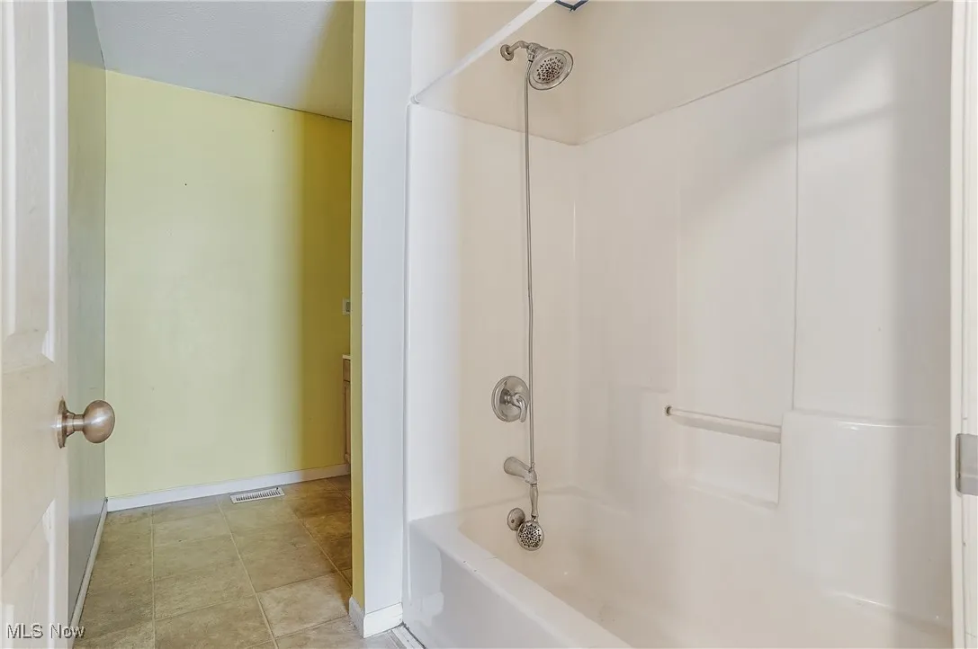 Bathroom with shower / bath combination and tile patterned floors