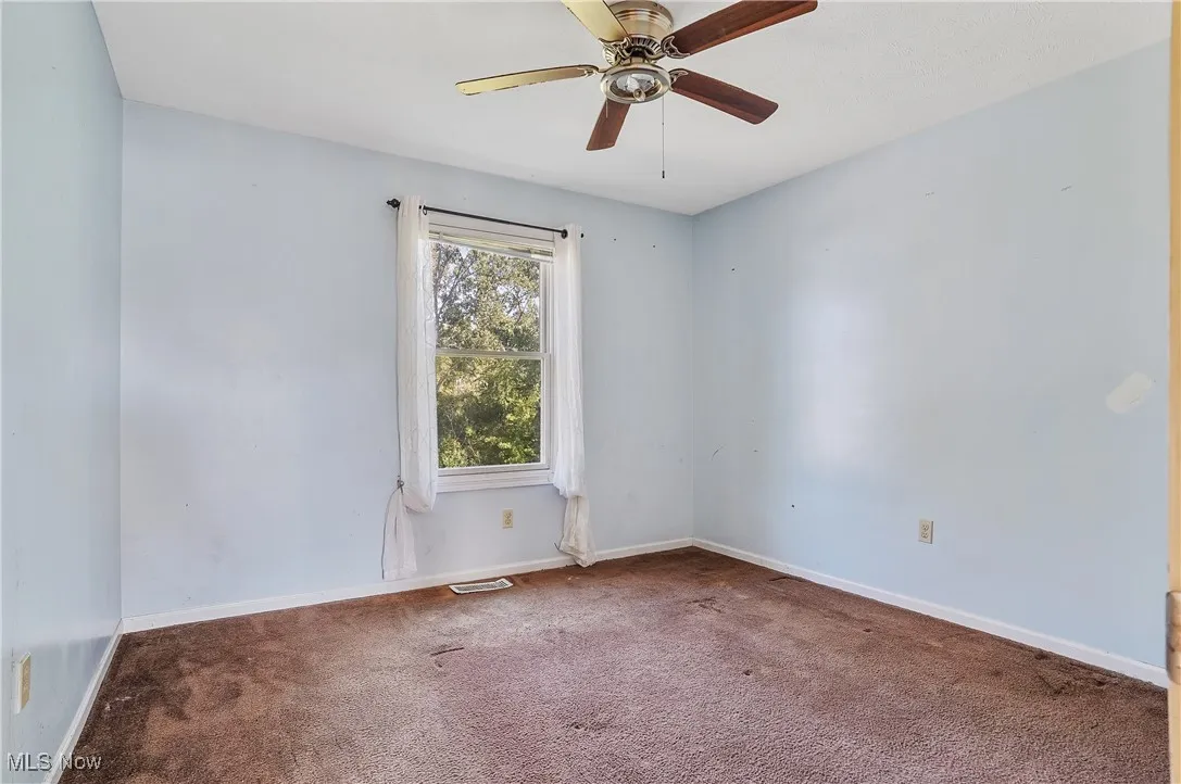 Unfurnished room featuring carpet flooring and ceiling fan