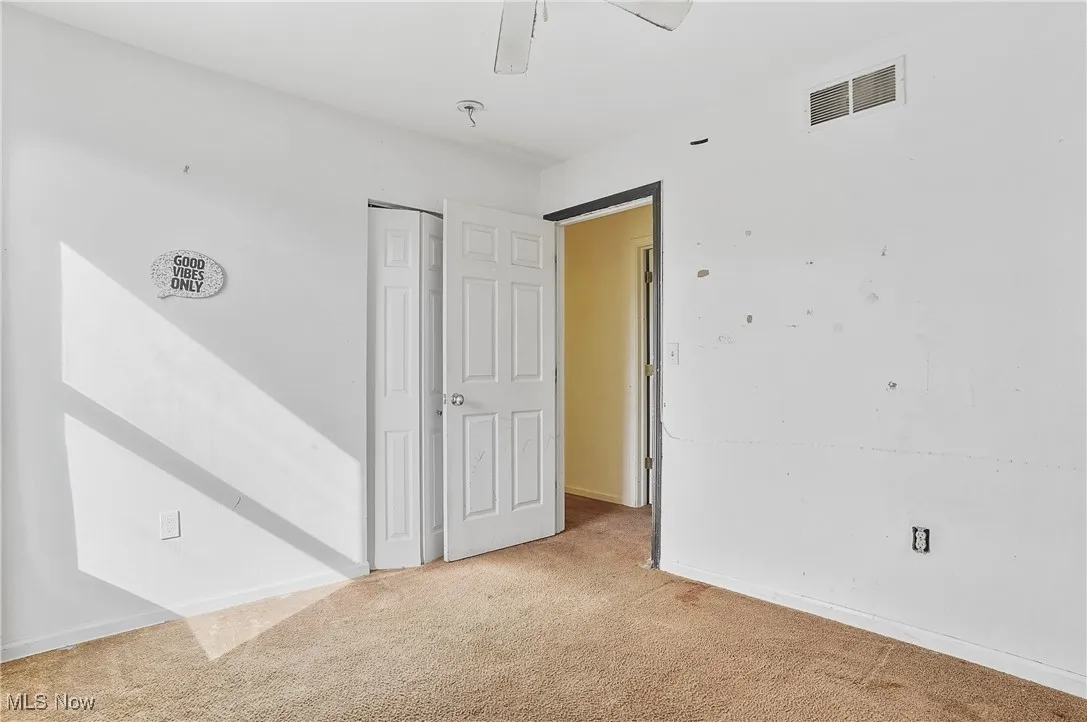 Carpeted empty room featuring baseboards and ceiling fan