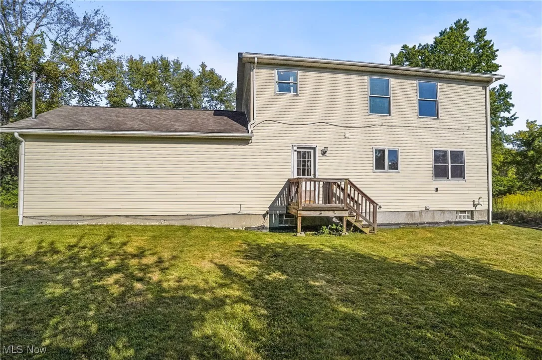 Back of property with a lawn