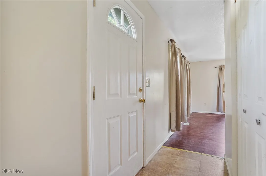 Hall with light tile patterned floors and baseboards