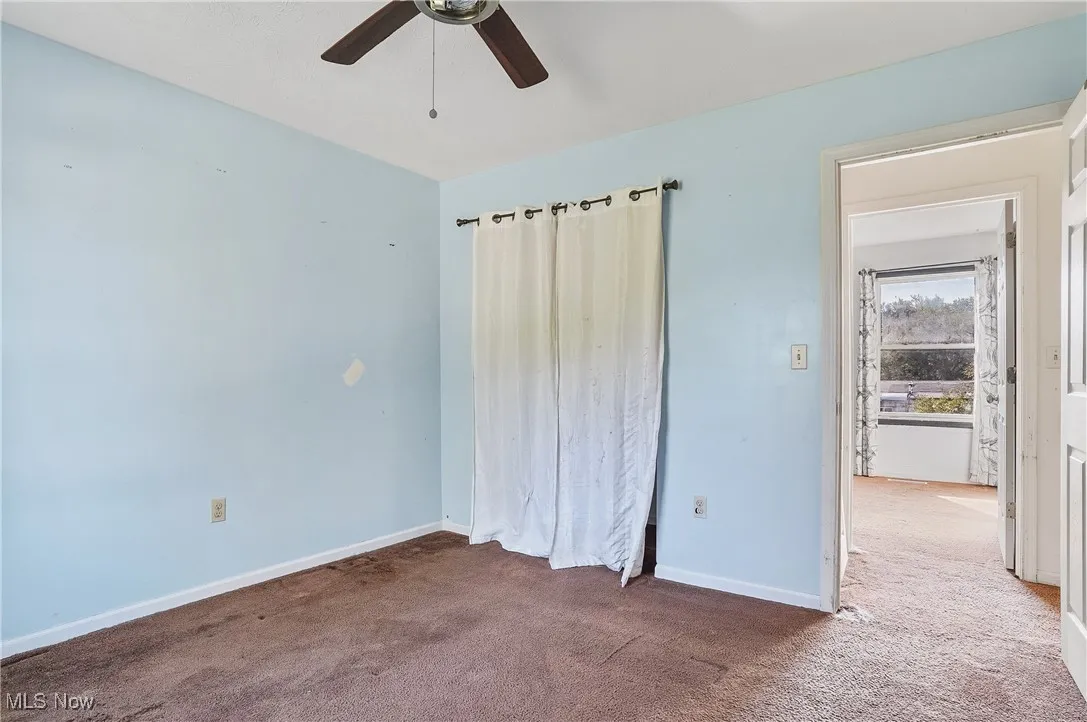 Unfurnished bedroom with carpet floors and a ceiling fan