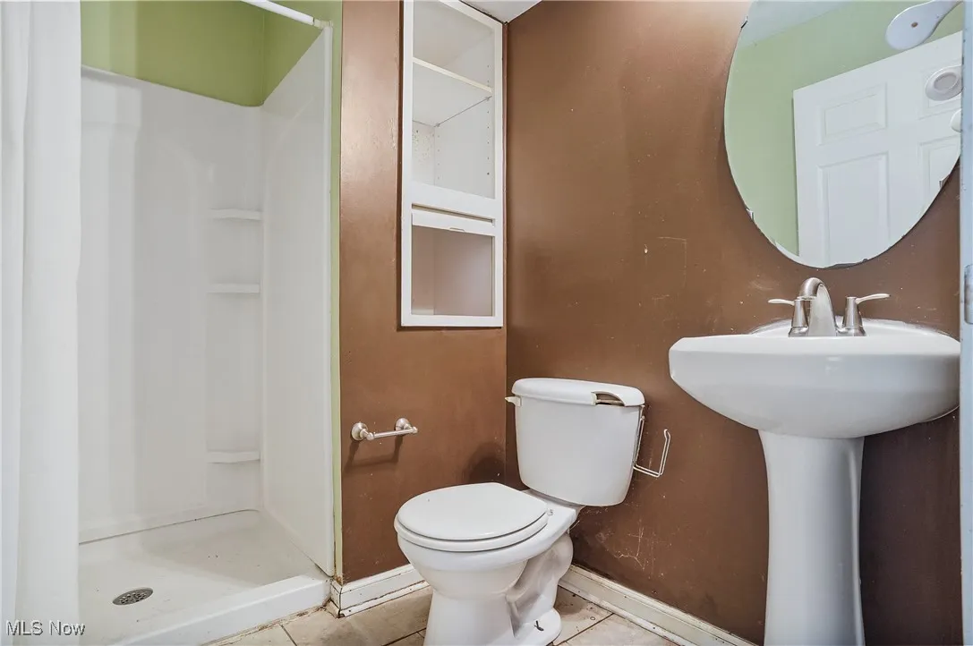 Full bathroom with tile patterned flooring and a shower stall