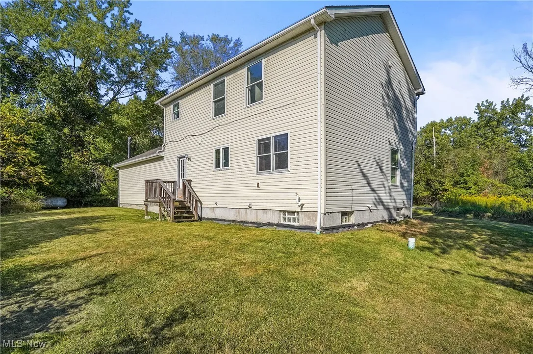 Rear view of property with a lawn