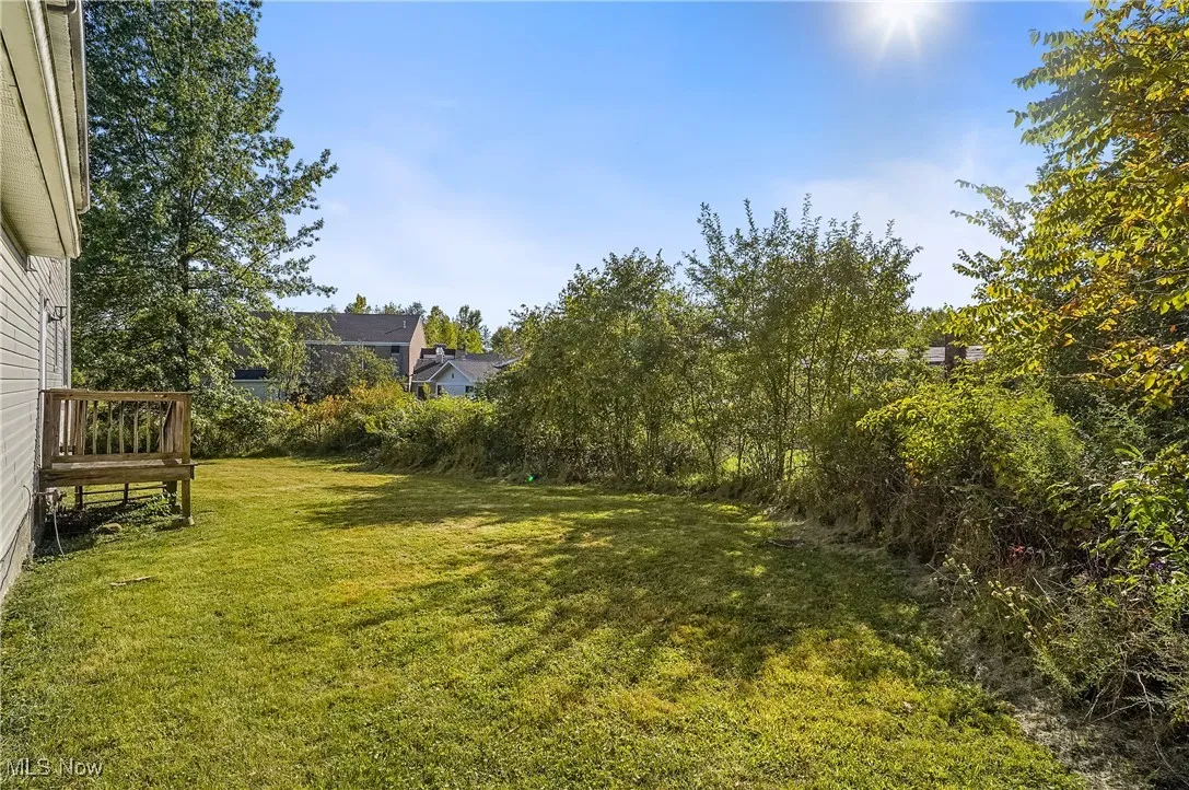 View of green lawn with a wooden deck