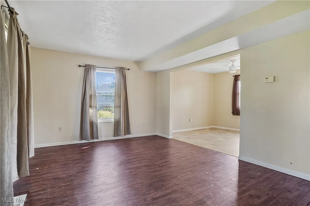 Spare room featuring dark wood-style floors and a ceiling fan