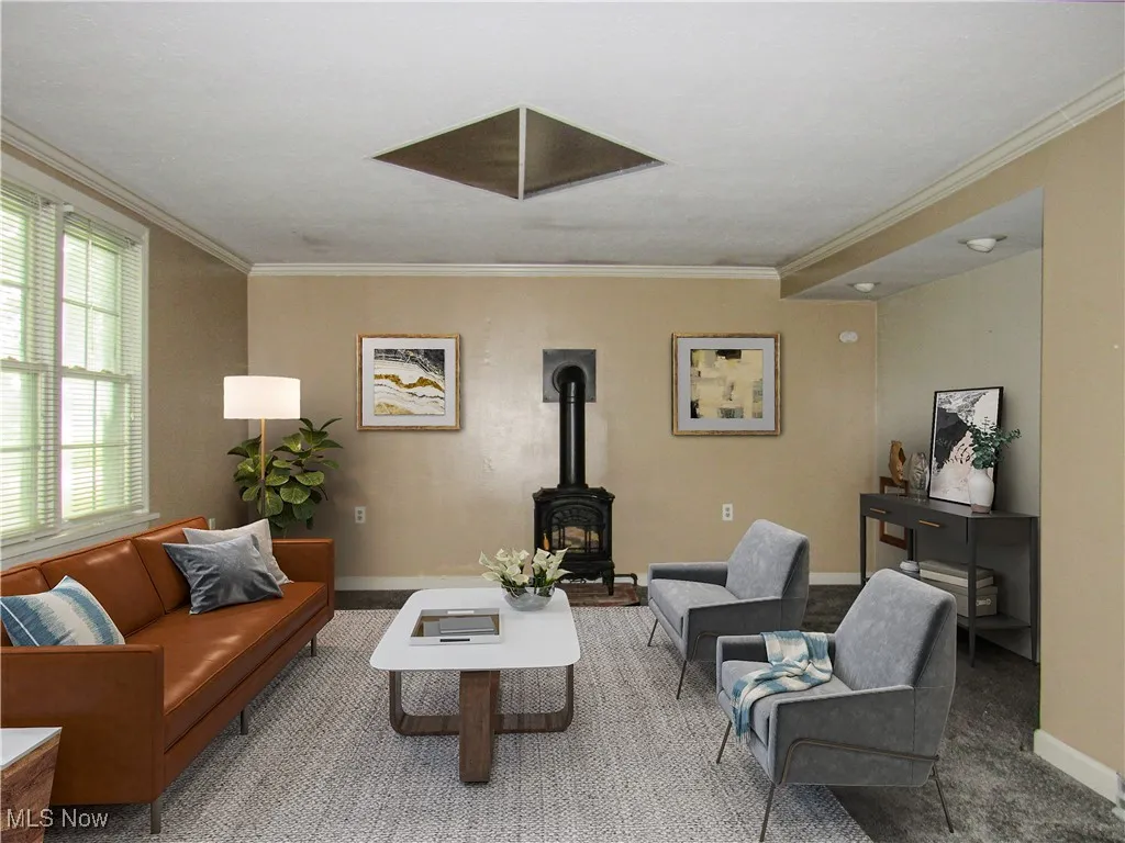 Living room featuring crown molding, a wood stove, and carpet floors