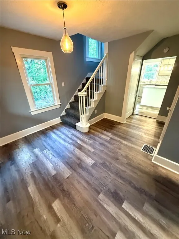 Living room featuring stairs and dark wood-style flooring