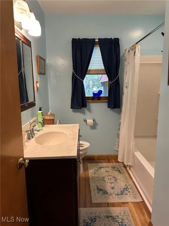 Full main bathroom featuring shower / bath combination with curtain, vanity,
