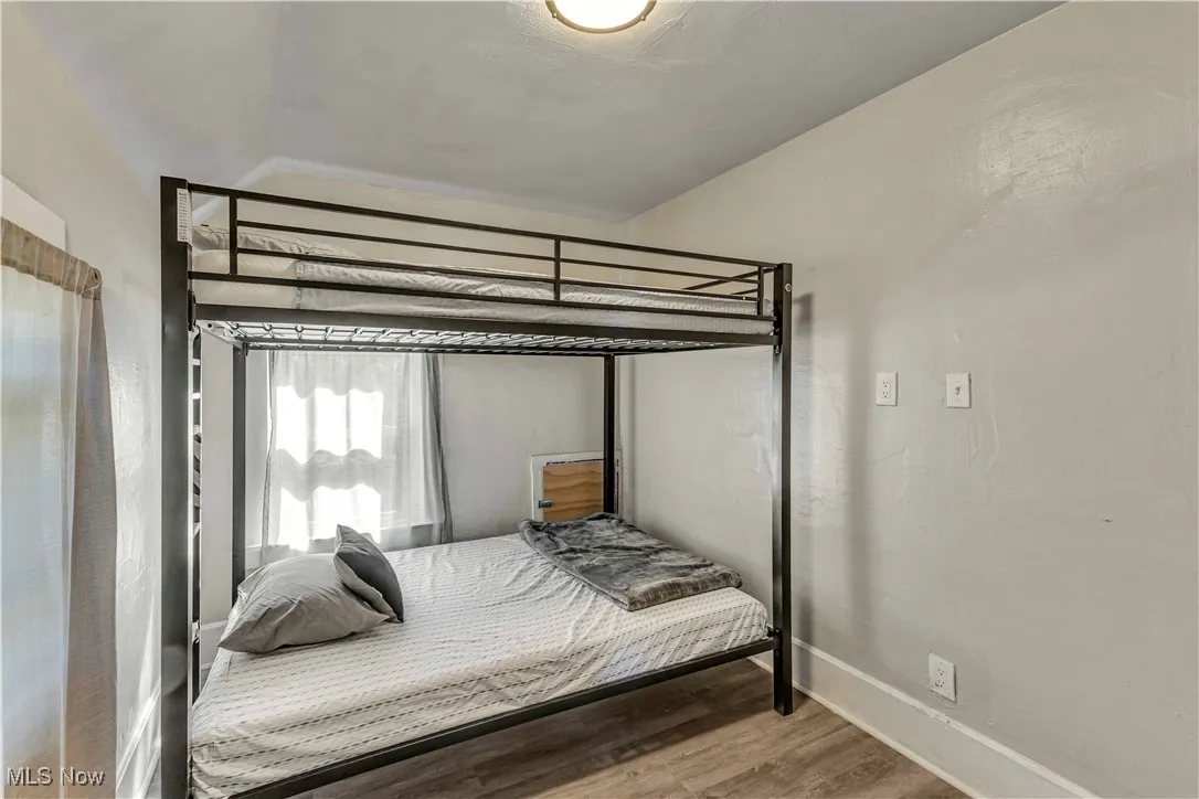 Bedroom with wood finished floors and baseboards