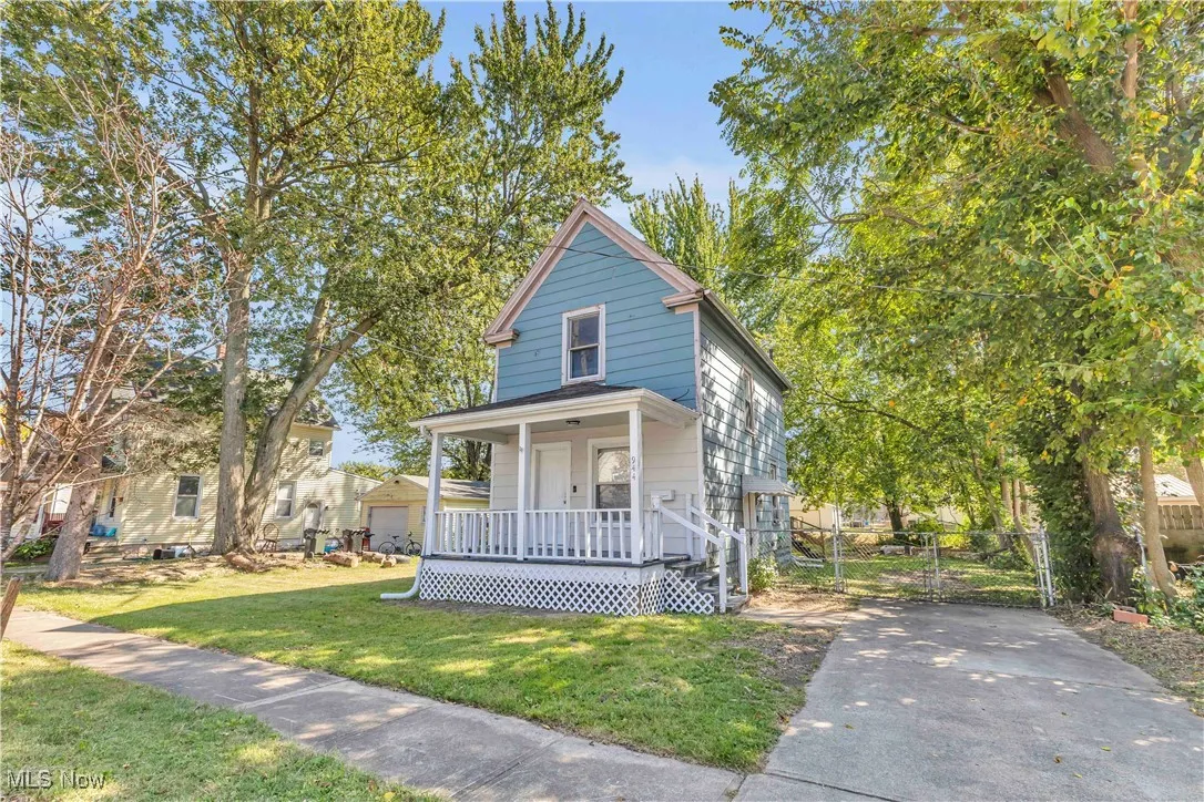 View of front of property featuring covered porch, a front lawn, and a gate