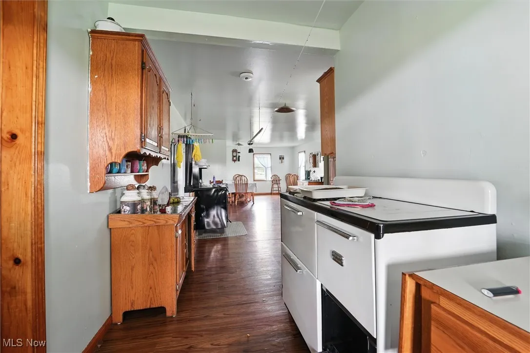 Kitchen with brown cabinetry and dark wood-style​​‌​​​​‌​​‌‌​‌‌​​​‌‌​‌​‌​‌​​​‌​​ flooring