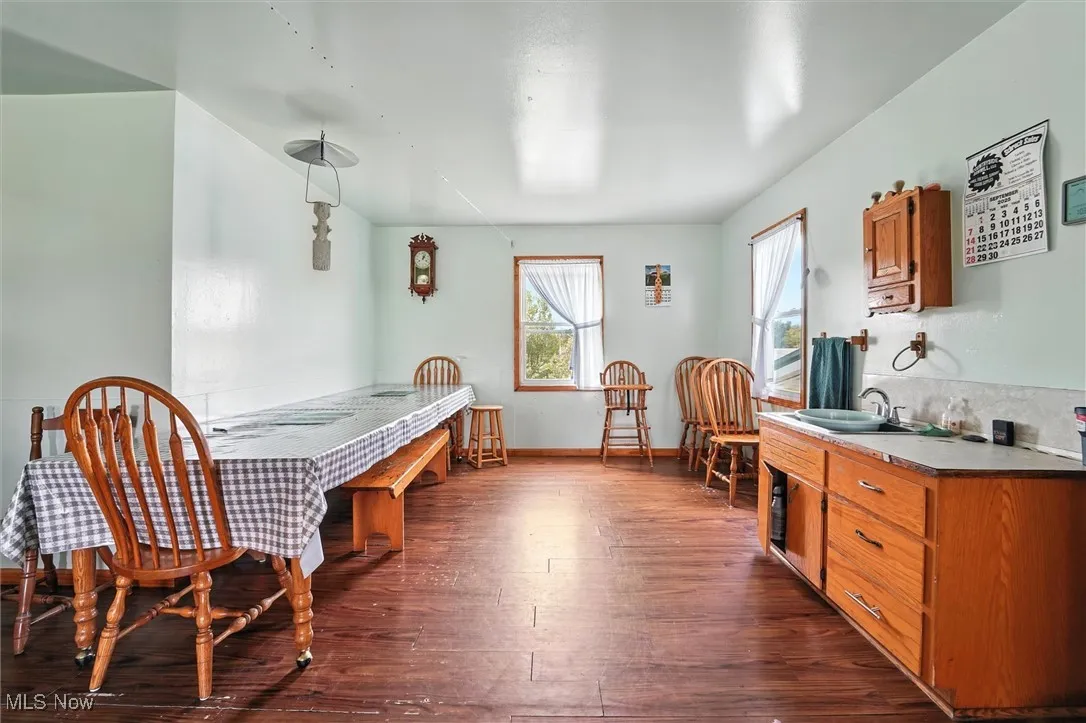 Dining space featuring dark wood finished floors and baseboards