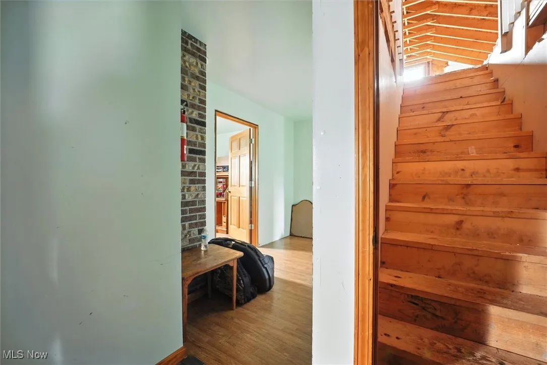 Staircase with wood finished floors leading to the attic