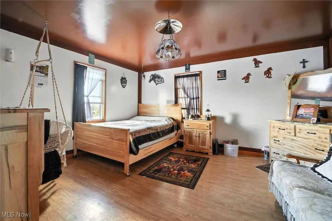Bedroom with wood finished floors and baseboards