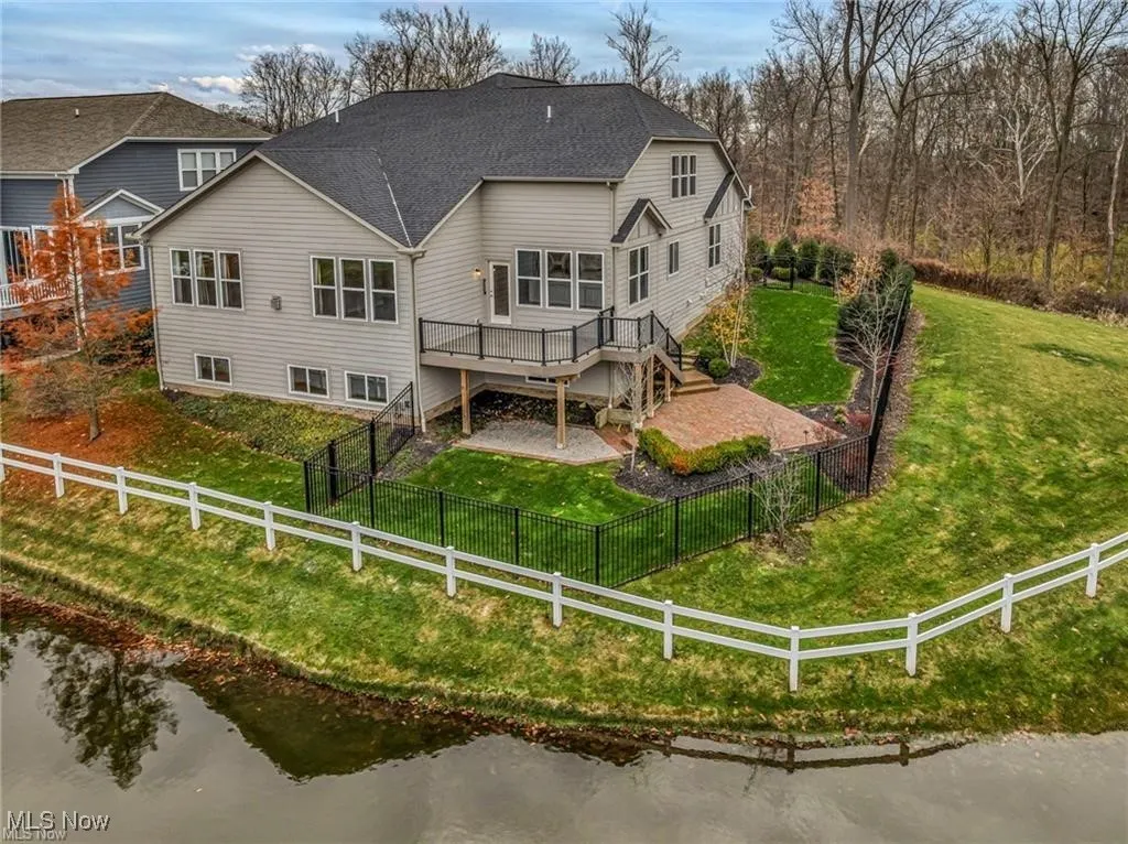 Back of house featuring stairway, a fenced backyard, a wooden deck, and a shingled roof