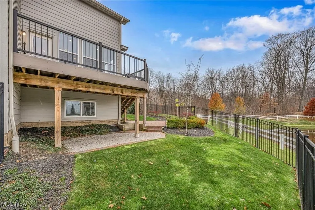 Fenced backyard featuring a wooden deck and a patio area