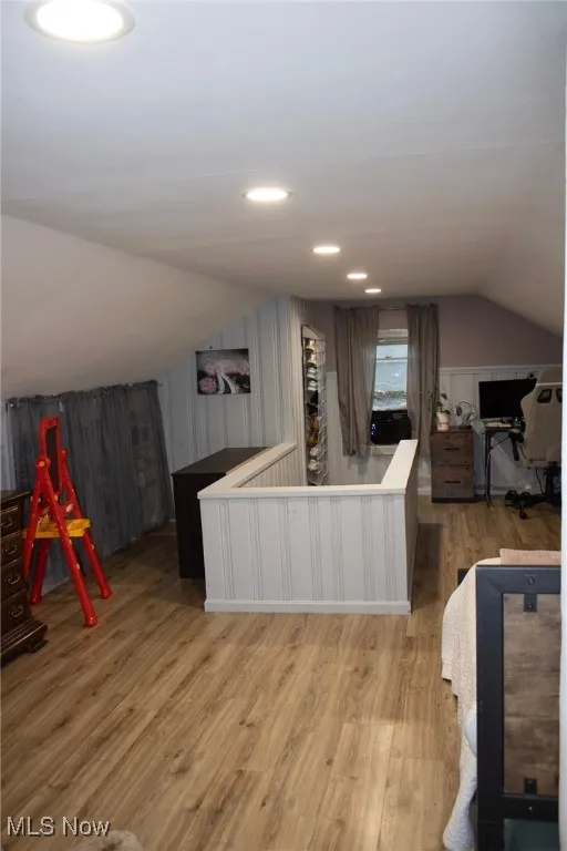 Bar with lofted ceiling, light wood-type flooring, white cabinets, recessed lighting, and light countertops