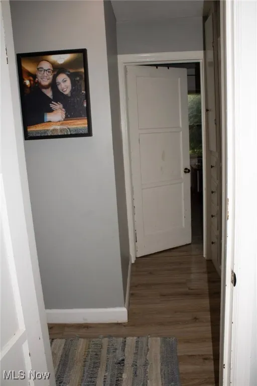 Corridor with wood finished floors and baseboards