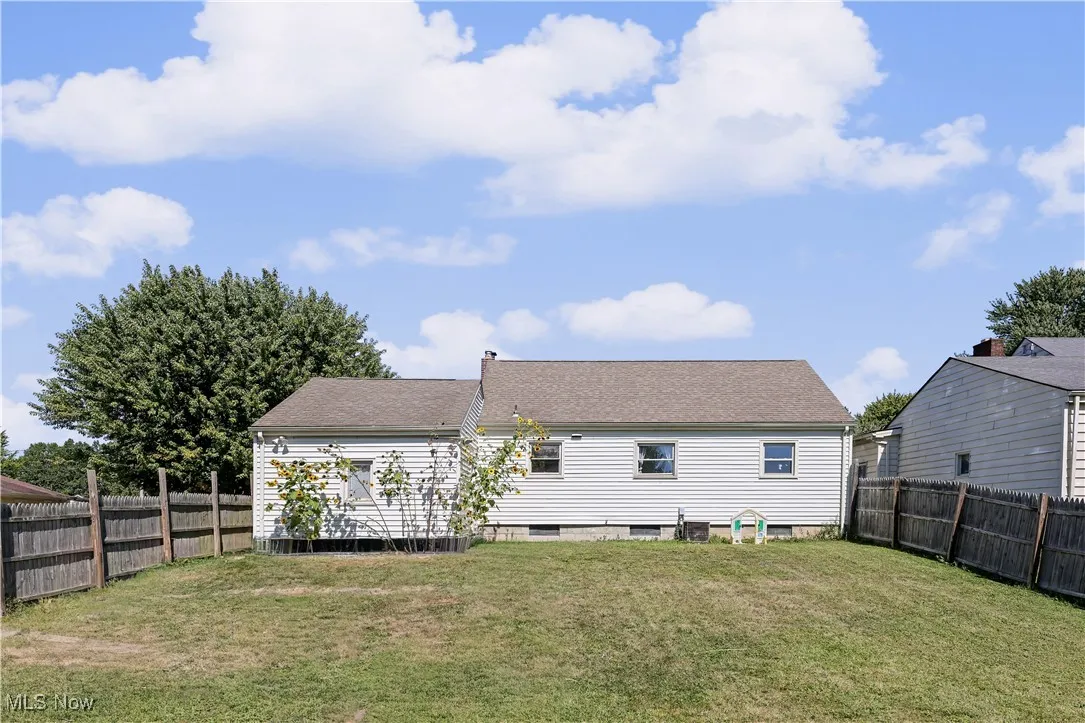 Back of property with roof with shingles, a fenced backyard, and a chimney