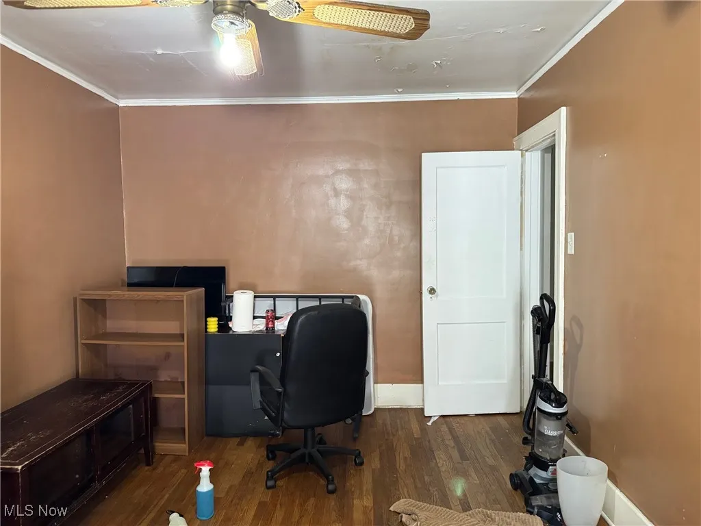 Home office featuring crown molding, dark wood-style floors, and ceiling fan