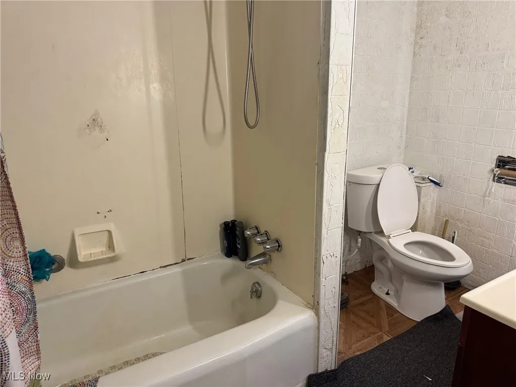 Full bathroom featuring tile walls, shower / tub combo, and vanity