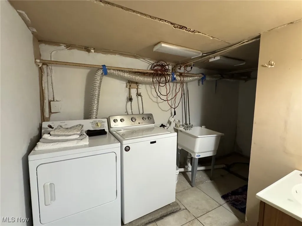 Washroom featuring light tile patterned floors and independent washer and dryer