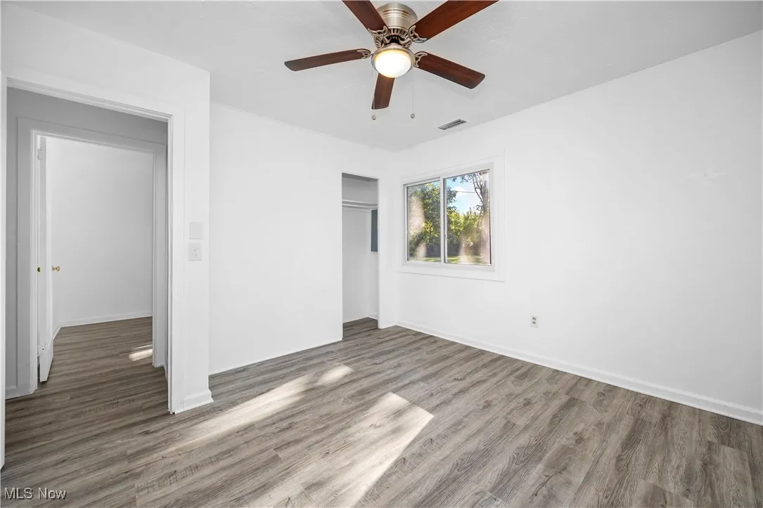 Unfurnished bedroom with wood finished floors, a closet, and ceiling fan